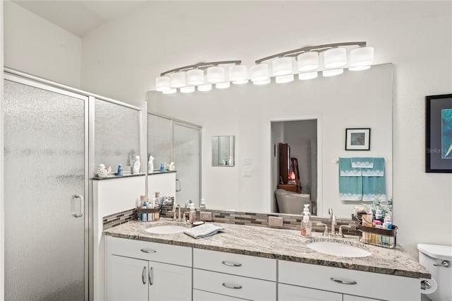 bathroom with vanity, a shower with shower door, and toilet