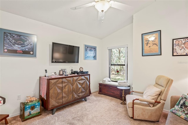 sitting room with ceiling fan, vaulted ceiling, and light carpet