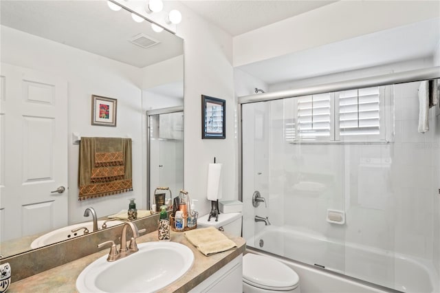 full bathroom with toilet, vanity, and shower / bath combination with glass door