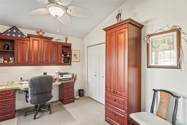 office with lofted ceiling, built in desk, light colored carpet, and ceiling fan