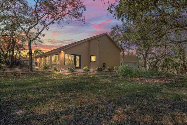 property exterior at dusk with a yard