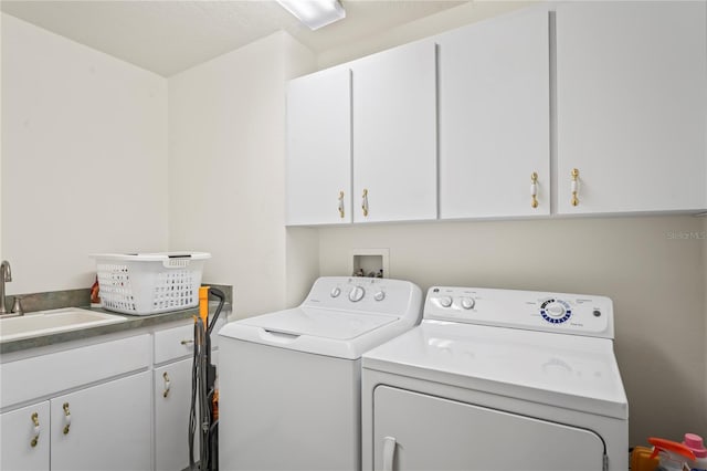 laundry area with cabinets, independent washer and dryer, and sink