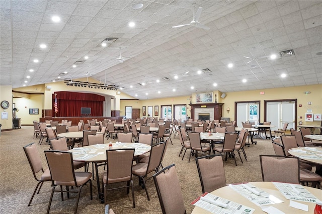 carpeted dining room featuring lofted ceiling and ceiling fan