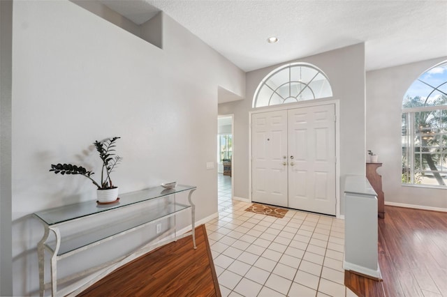 foyer entrance with a textured ceiling and light wood-type flooring