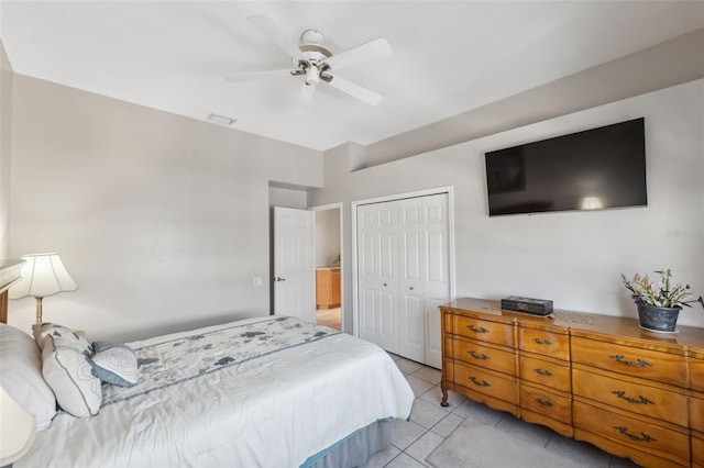 tiled bedroom featuring ceiling fan and a closet