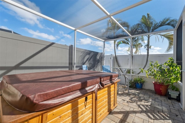 view of patio featuring a hot tub and a lanai