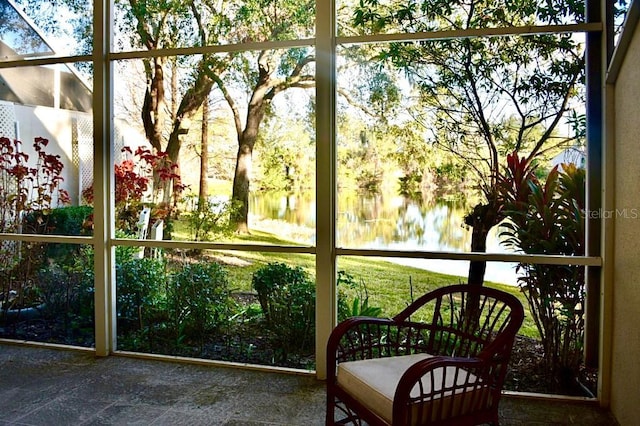 sunroom featuring a water view