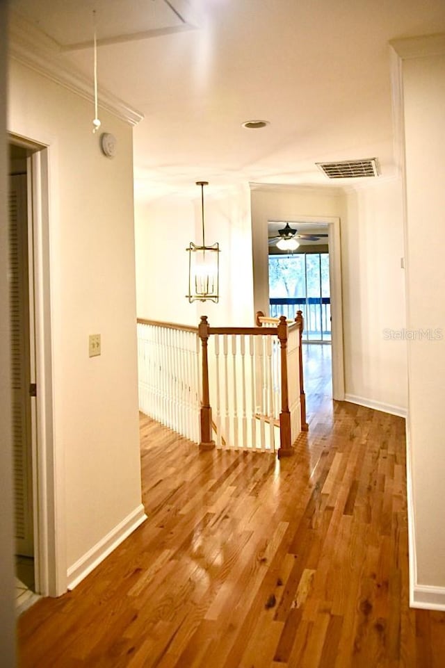 hall featuring wood-type flooring and crown molding