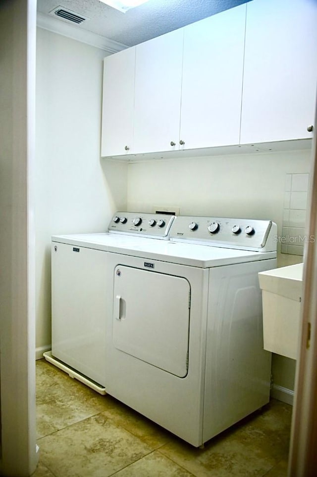 washroom featuring cabinets, separate washer and dryer, and sink