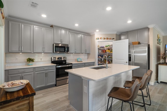 kitchen with appliances with stainless steel finishes, gray cabinets, and sink