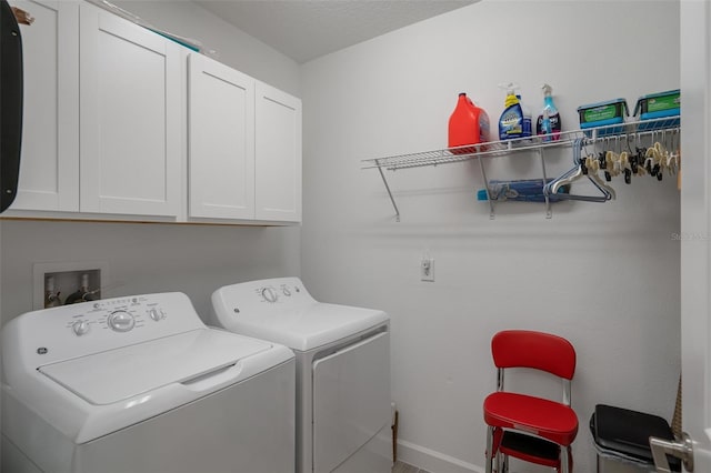 clothes washing area featuring cabinets and independent washer and dryer