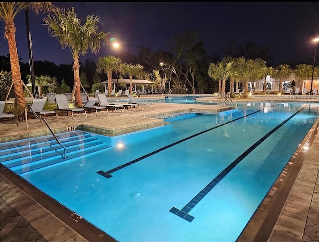 pool at twilight featuring a patio