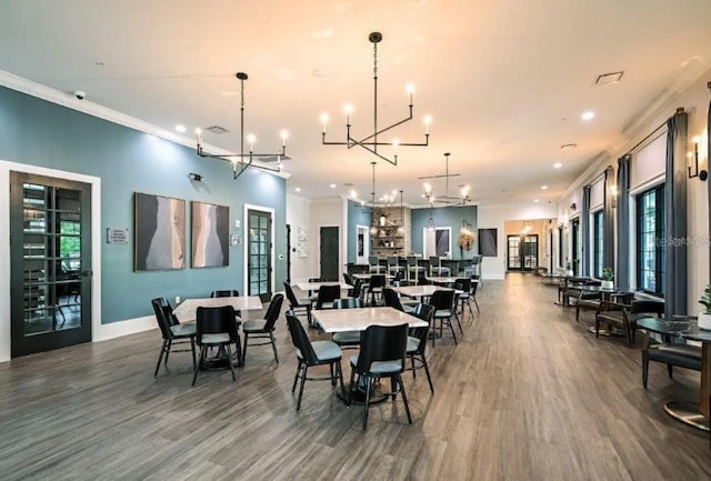 dining area featuring ornamental molding, dark hardwood / wood-style flooring, and a notable chandelier