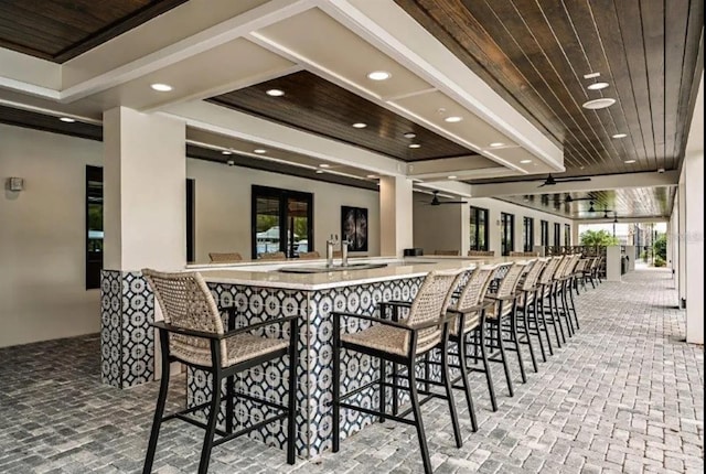 dining room with french doors, plenty of natural light, wet bar, and wooden ceiling