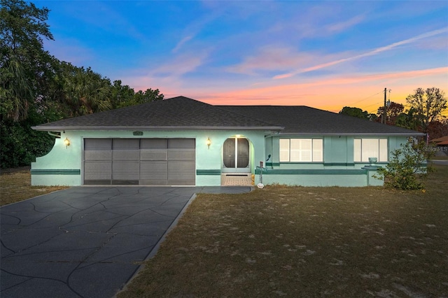 single story home with a garage and a lawn