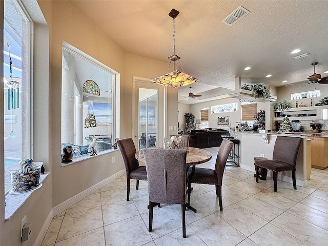 dining room with a textured ceiling, ceiling fan, and light tile patterned flooring