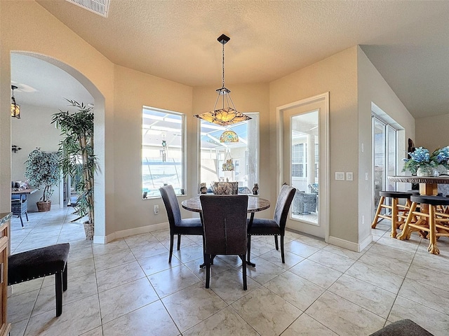 tiled dining area featuring a textured ceiling