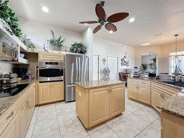 kitchen featuring sink, a kitchen island, light brown cabinets, and appliances with stainless steel finishes