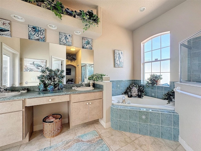 bathroom with plus walk in shower, vanity, and a textured ceiling