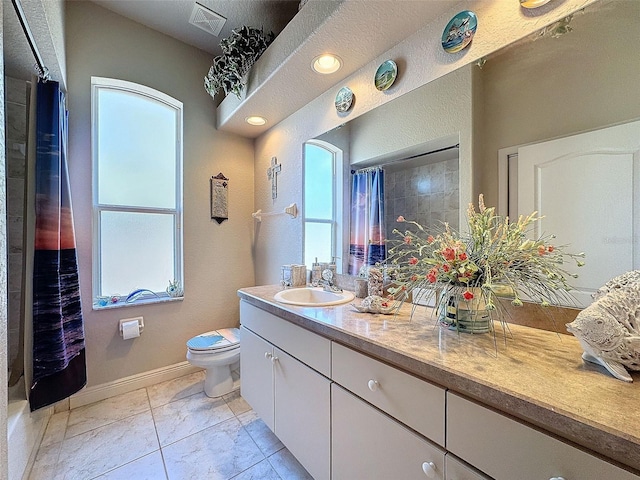 bathroom featuring vanity, tile patterned floors, toilet, and walk in shower