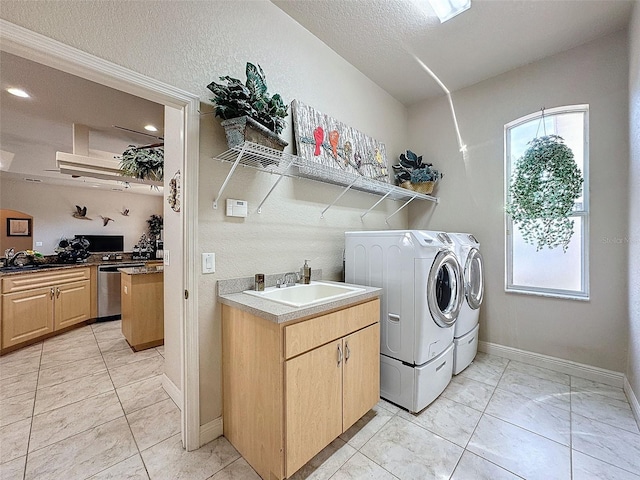 laundry area featuring sink, washer and dryer, and a textured ceiling