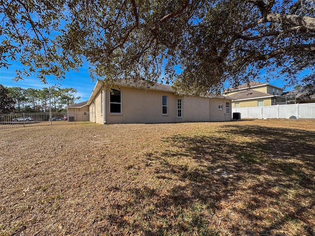 rear view of property featuring a yard and central air condition unit