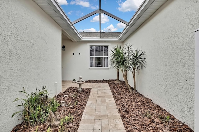 exterior space with a shingled roof and stucco siding