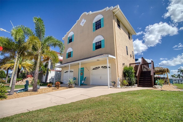 view of front of home with driveway, stairway, an attached garage, and stucco siding