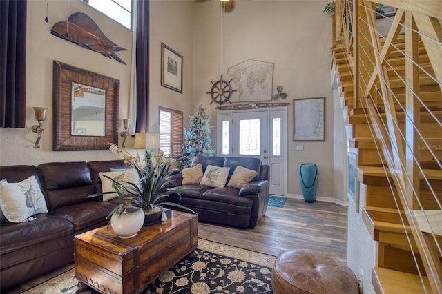 living room with hardwood / wood-style floors and a towering ceiling