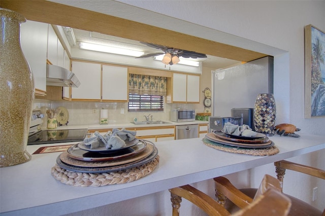 kitchen with white cabinetry, appliances with stainless steel finishes, sink, and backsplash