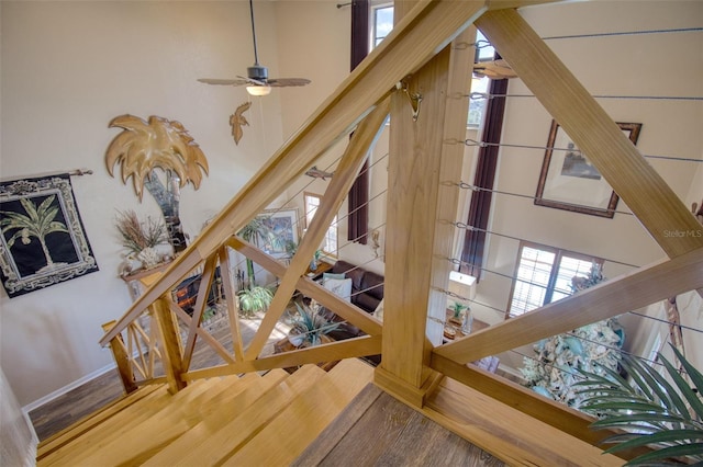 stairway featuring a towering ceiling and hardwood / wood-style floors