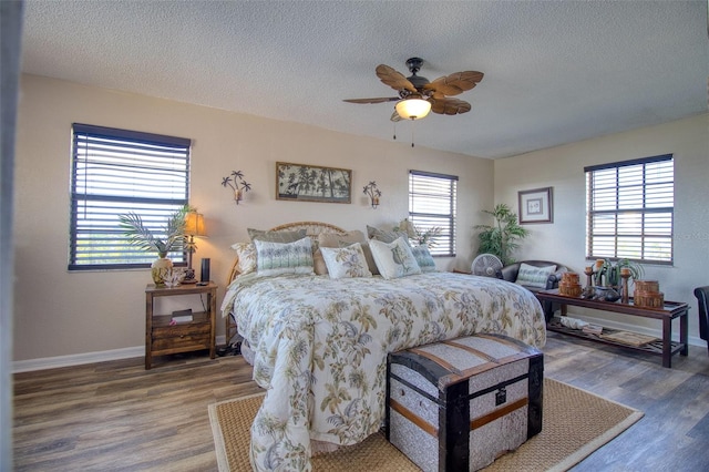 bedroom with multiple windows, wood-type flooring, and a textured ceiling