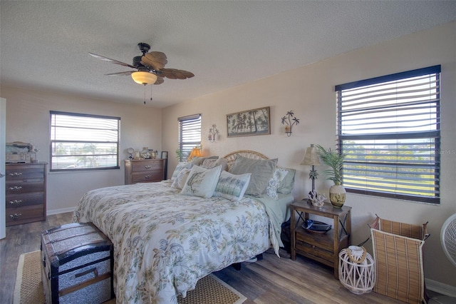 bedroom featuring a textured ceiling, ceiling fan, wood finished floors, and baseboards