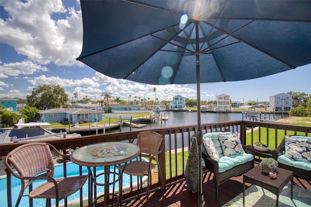 wooden deck with a yard and a water view