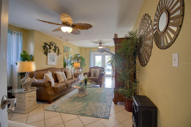 living room featuring a ceiling fan, a textured ceiling, and light tile patterned floors