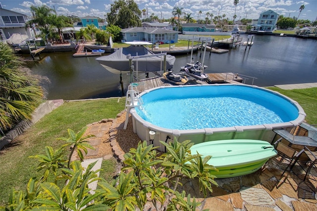 outdoor pool featuring a water view, a residential view, and a dock