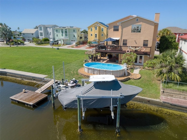 view of dock featuring a lawn, a water view, boat lift, and an outdoor pool