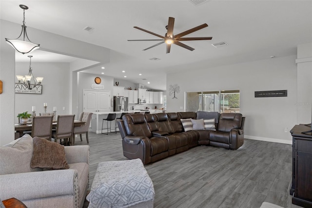 living room with lofted ceiling, ceiling fan with notable chandelier, and light hardwood / wood-style floors