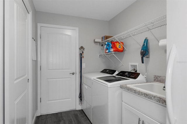 clothes washing area with dark hardwood / wood-style floors and washing machine and dryer