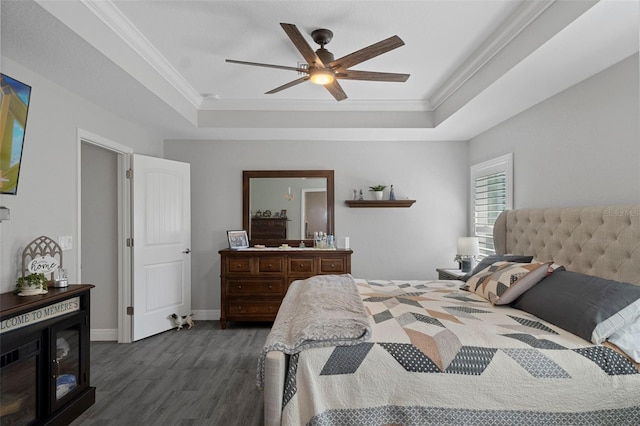 bedroom with dark hardwood / wood-style flooring, a tray ceiling, and ornamental molding