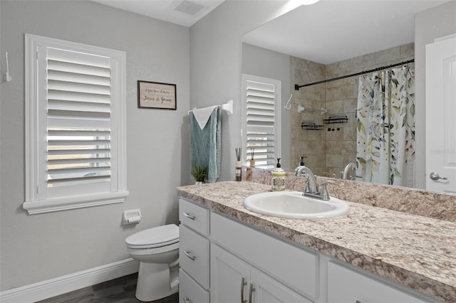 bathroom featuring plenty of natural light, toilet, a shower with shower curtain, and vanity