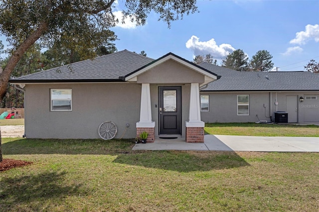 view of front of property featuring central AC and a front lawn