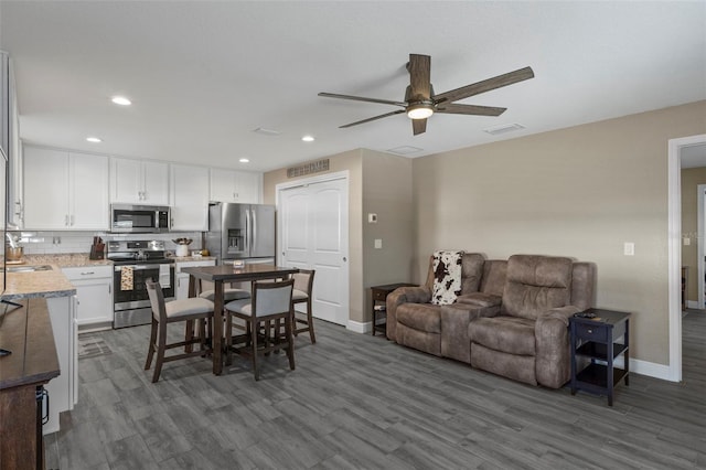 interior space featuring ceiling fan, sink, and dark hardwood / wood-style flooring