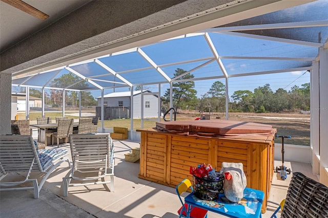 view of patio with a hot tub and glass enclosure