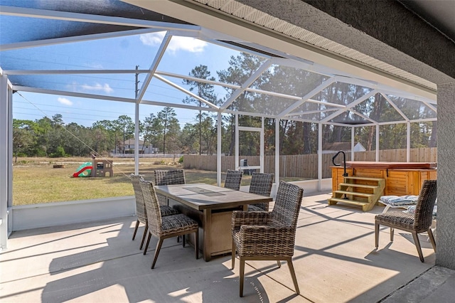 view of patio / terrace featuring a hot tub and glass enclosure