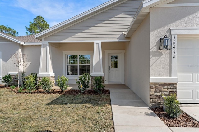 doorway to property featuring a garage and a lawn