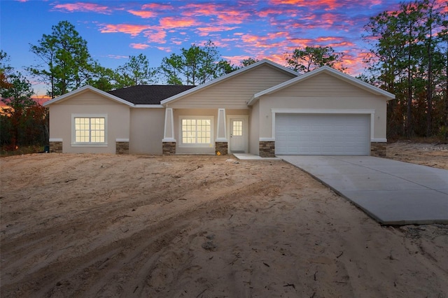 single story home featuring concrete driveway, a garage, and stone siding