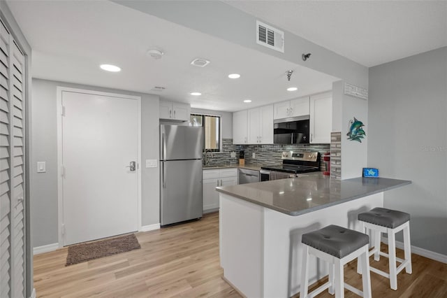 kitchen featuring white cabinetry, stainless steel appliances, and kitchen peninsula