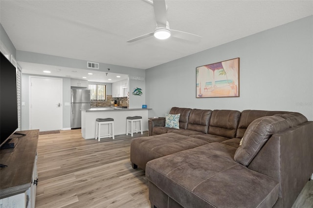 living room with light hardwood / wood-style floors and ceiling fan