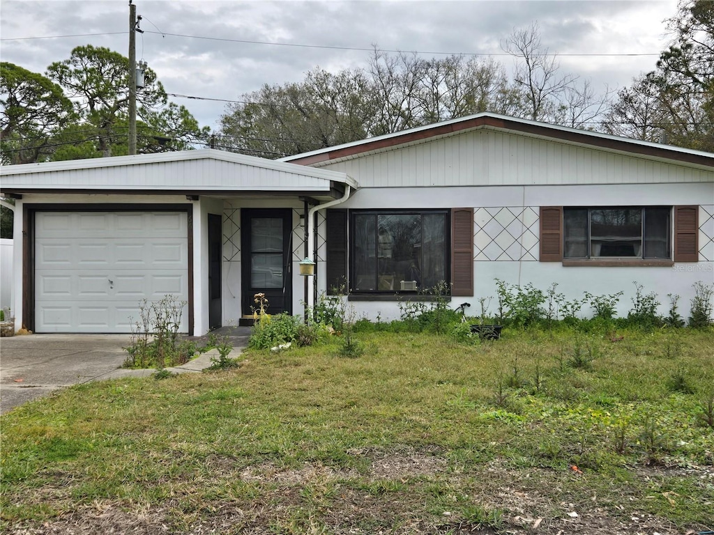 ranch-style house with a garage and a front lawn